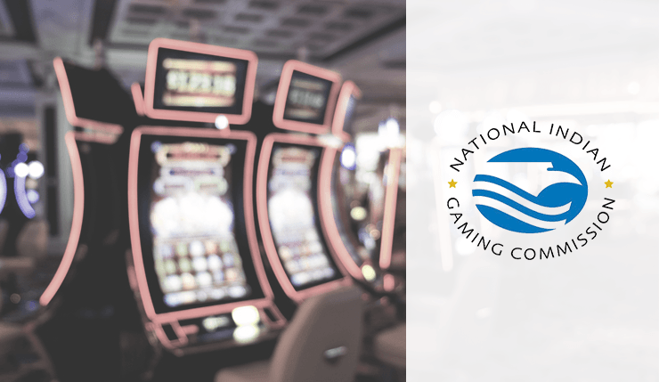 The logo of the National Indian Gaming Commission sites in front of slot machines. 