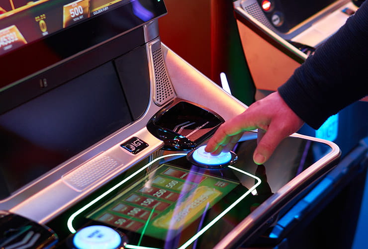 A man playing a slot machine.