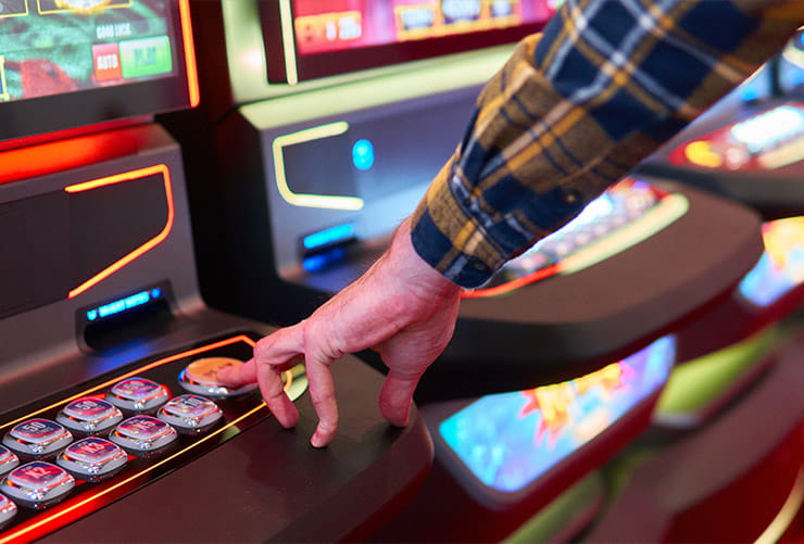 A man playing a slot machine.