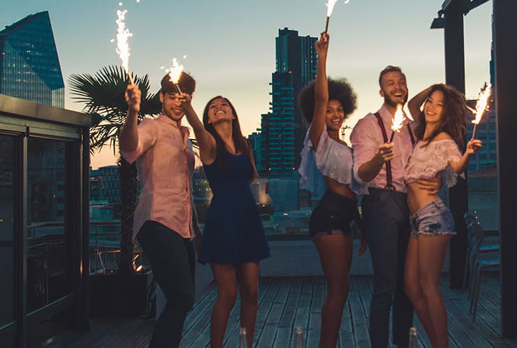 A group of young socialites celebrate with fireworks.