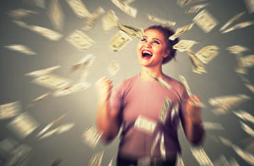 A  woman getting showered in money.