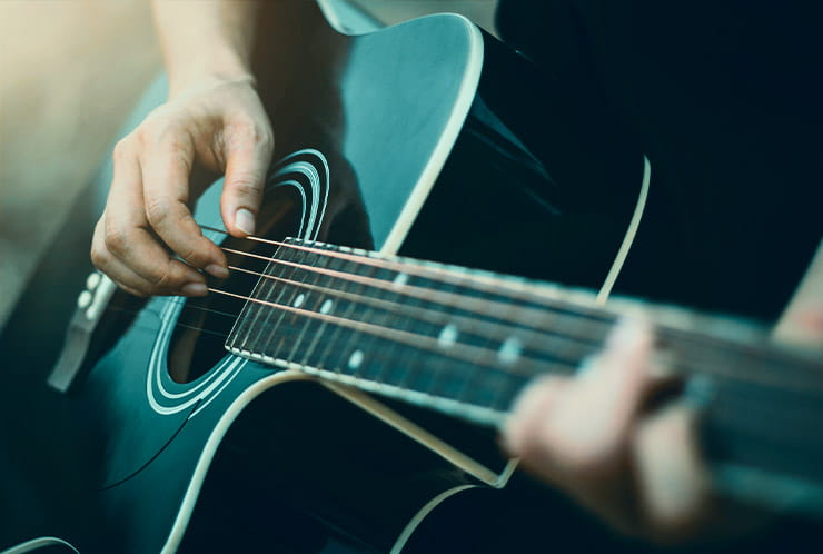 A performer plays a guitar.